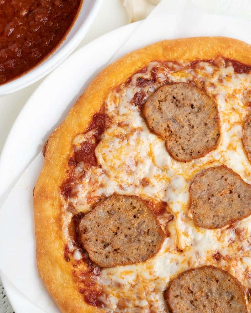 slice keto meatballs on fathead pizza crust with marinara sauce on the side