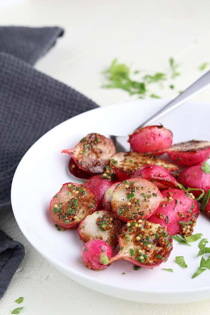 roasted radishes plated next to chopped parsley