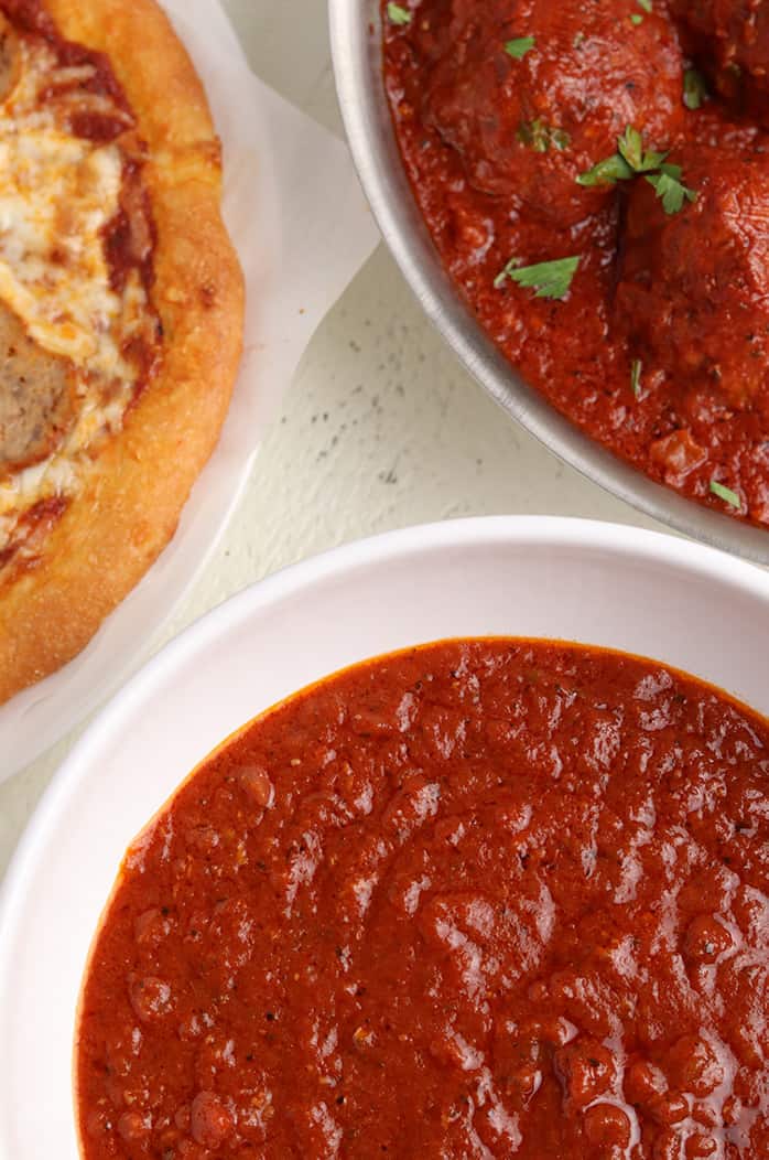 keto pizza sauce next to meatballs and pizza