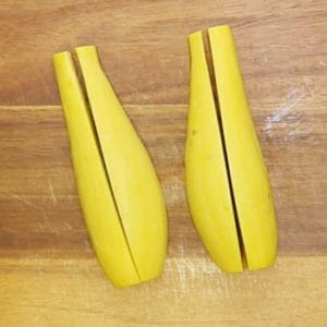 yellow squash quartered on a cutting board, lengthwise