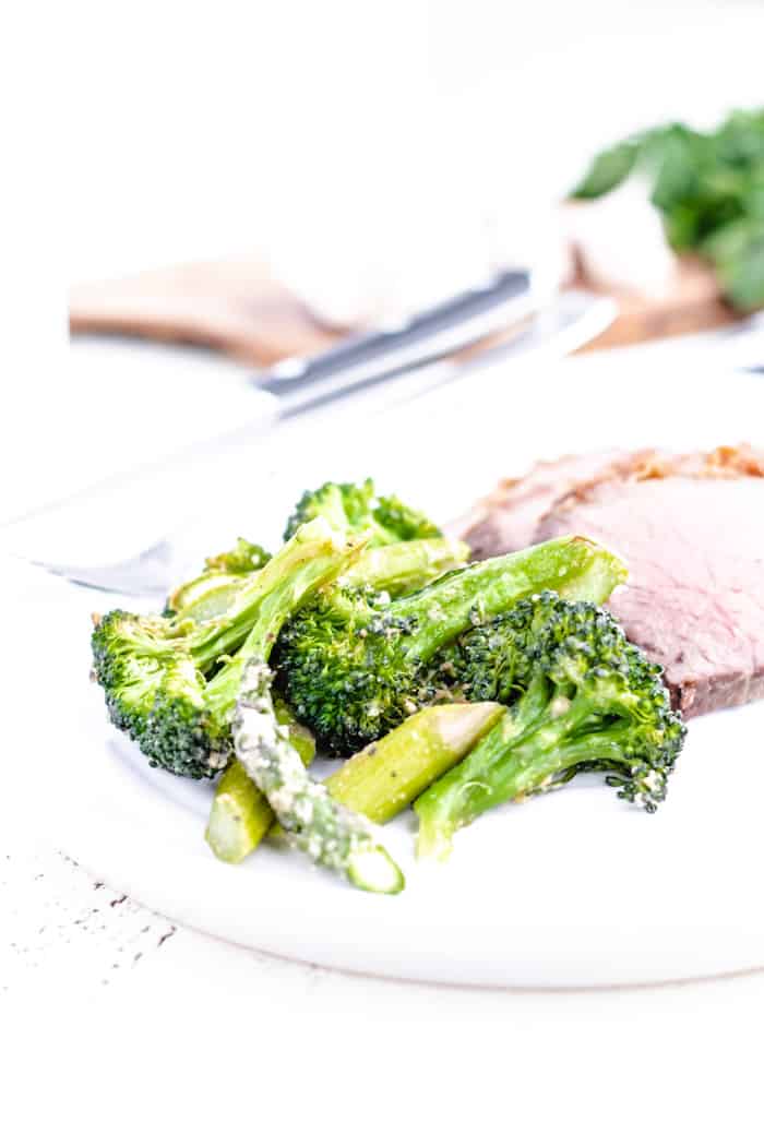 broccoli and asparagus roasted and plated next to sliced roast beef