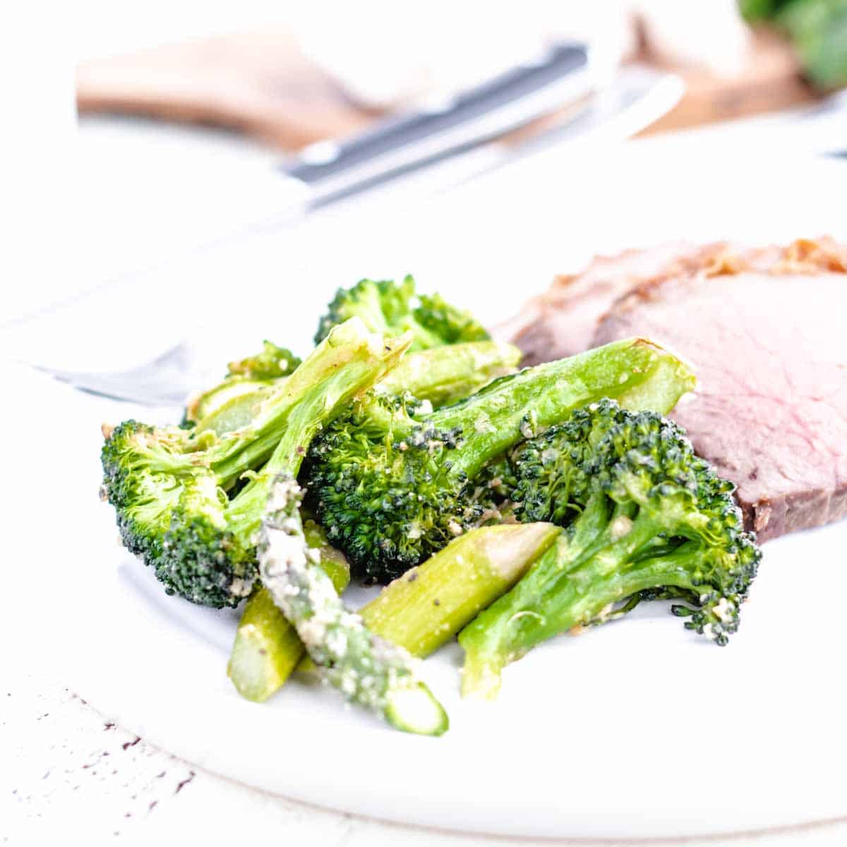 roasted broccoli and asparagus with sliced roast beef on a plate
