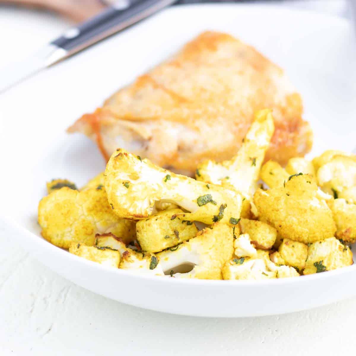 roasted curry-spiced cauliflower and turnips next to seared chicken thigh