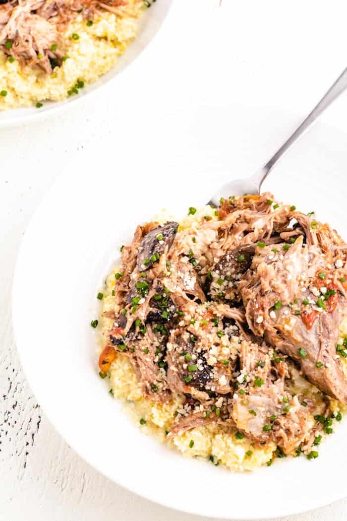 pulled pork on a plate with cauliflower polenta