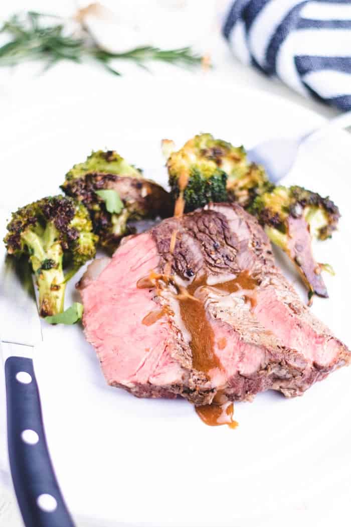 new york strip steak with broccoli being sauce on a plate