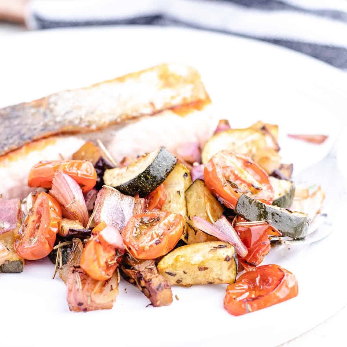roasted provencal veggies next to salmon on a plate
