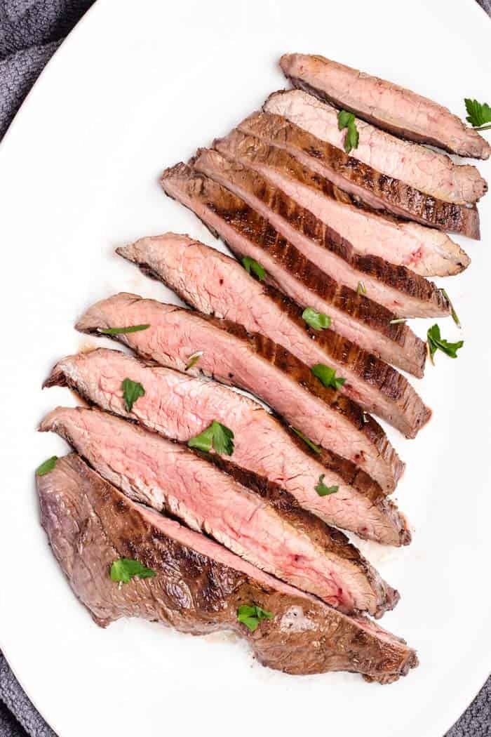 medium rare flank steak sliced thinly on a plate